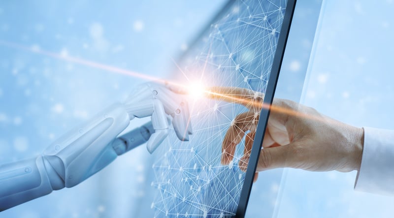 A robot hand mirroring a human hand pointing at a computer screen