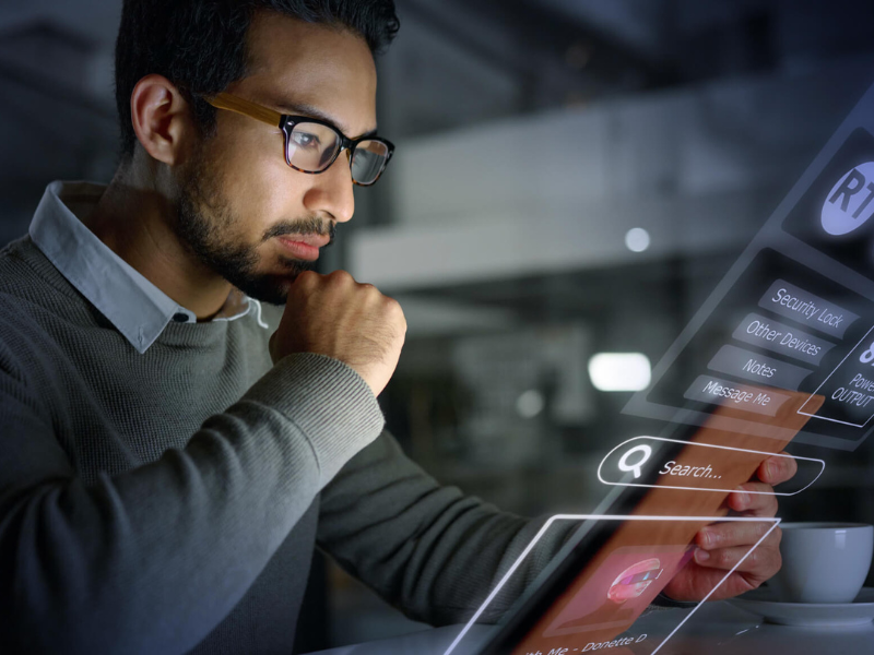 Man sitting at desk looking at a tablet