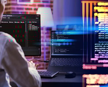 A-male-programmer-is-sitting-in-front-of-a-computer-screen-in-his-office-to-write-program-code