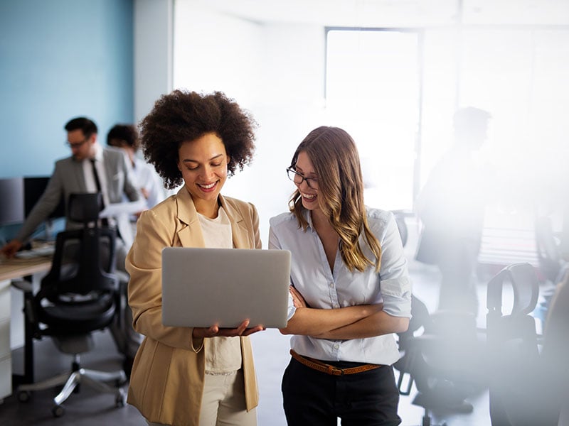 Happy multiethnic smiling business women working together in office