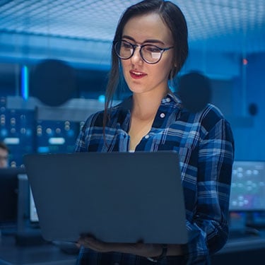 Portrait of a Smart Seductive Young Woman Wearing Glasses Holds Laptop