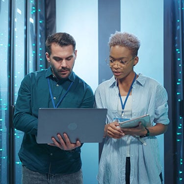 Professional diverse team of data center specialists coworking in server room