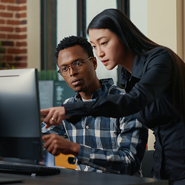 Software developers pointing at laptop screen