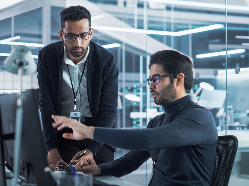 Portrait-of-Two-Young-Multiethnic-Software-Interface-Programmers-Chatting