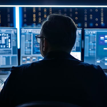 Professional-IT-Programer-Working-in-Data-Center-on-Desktop-Computer-with-Three-Displays
