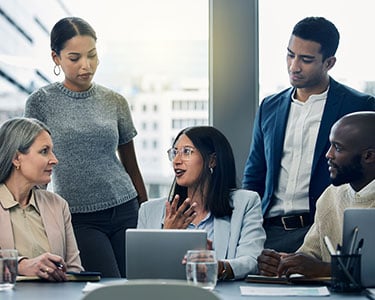 Shot-of-a-group-of-businesspeople-using-a-digital-tablet-during-a-meeting