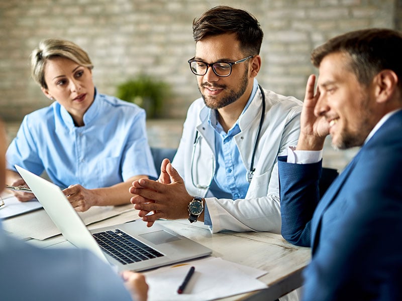 Team-of-doctors-and-businessman-using-computer-during-the-meeting-in-the-office
